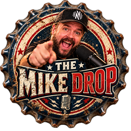 Red, white and navy bottle cap showing a grinning bearded man in a black cap pointing at the viewer beside a studio microphone, with "The Mike Drop" in bold lettering